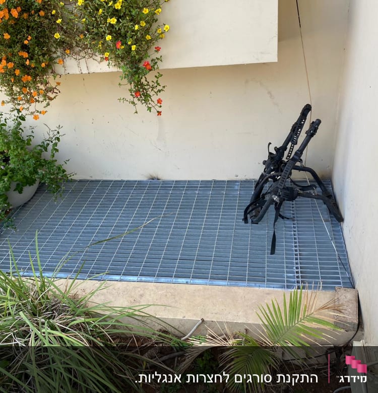 רשת מתכת על הרצפה עם מסגרת שחורה בצד